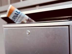 Ein Briefkasten mit einer Zeitung in der Öffnung