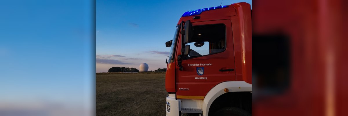 Ein Feuerwehrfahrzeug mit dem Radom im Hintergrund
