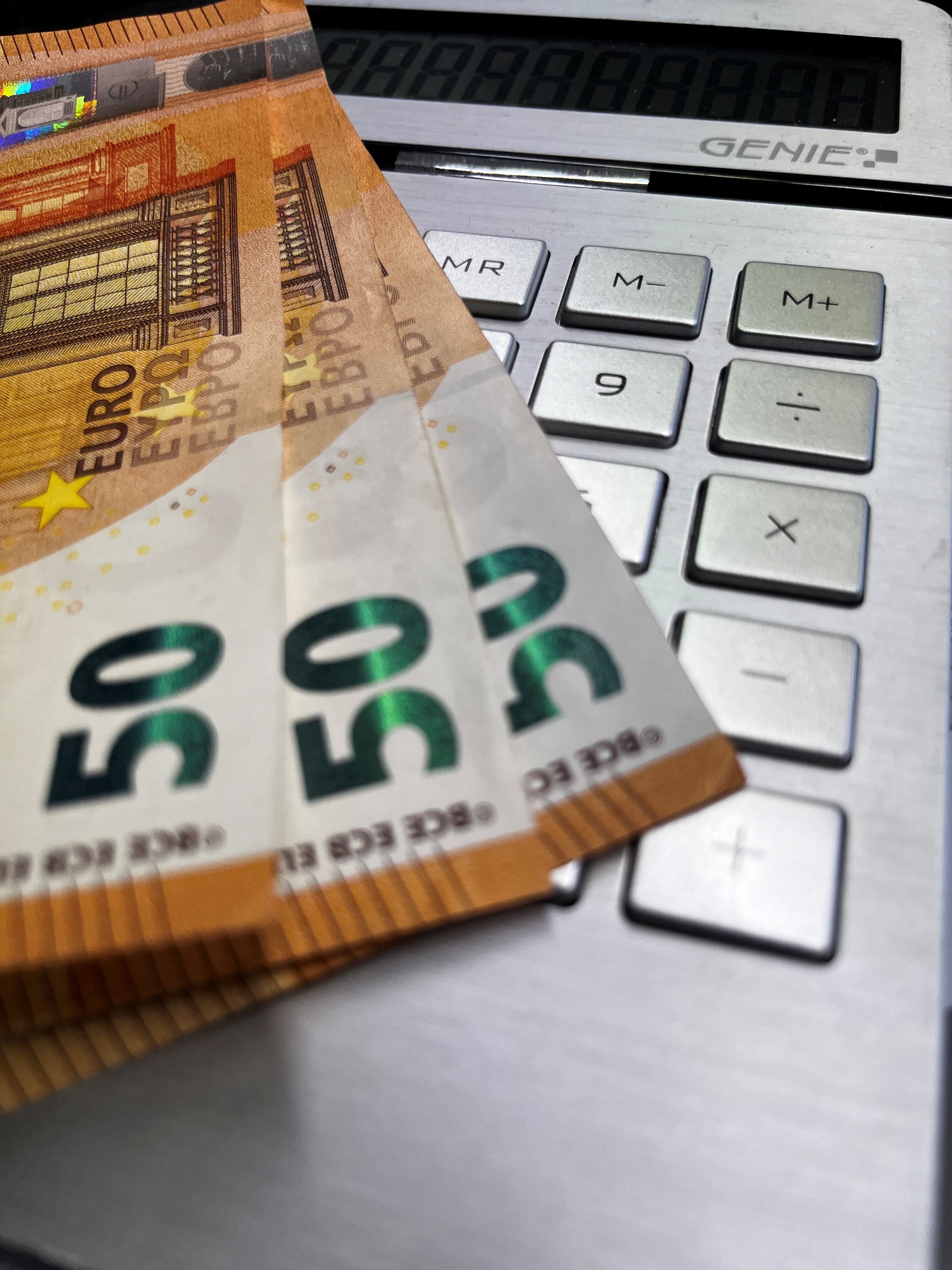 Ein Taschenrechner und Geldscheine