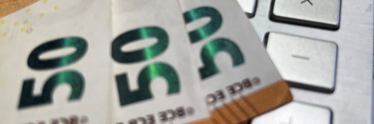 Ein Taschenrechner und Geldscheine