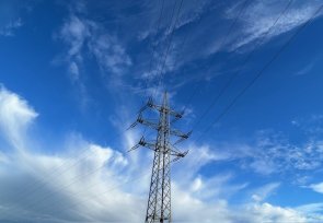Ein Strommast mit Wolken im Hintergrund