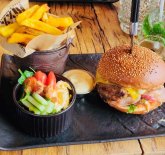 Teller mit einem Burger, Pommes und Salat