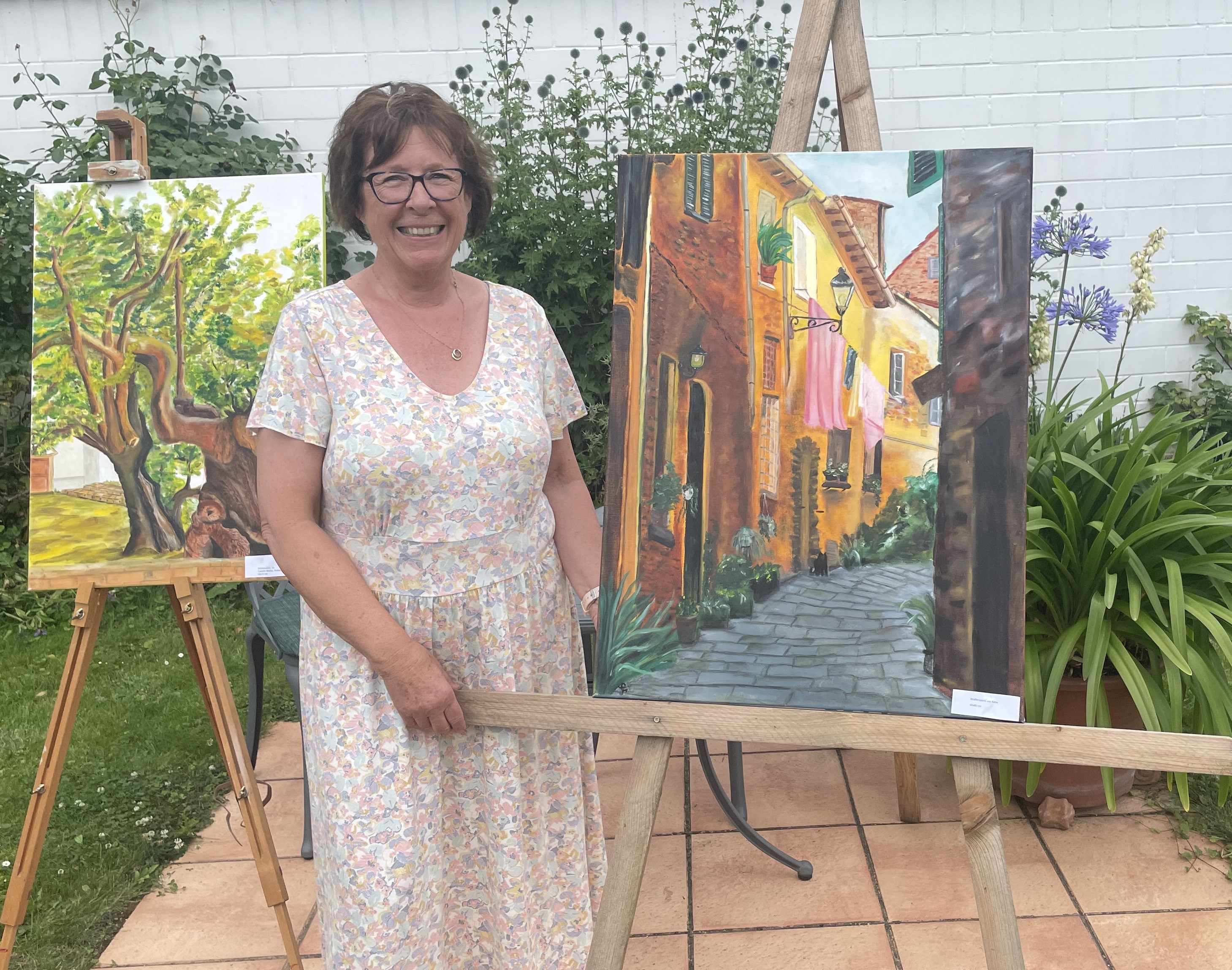 Gisela von den Driesch neben ihrem Bild „Straßenszene mit Katze“ Gisela von den Driesch neben ihrem Bild „Straßenszene mit Katze“