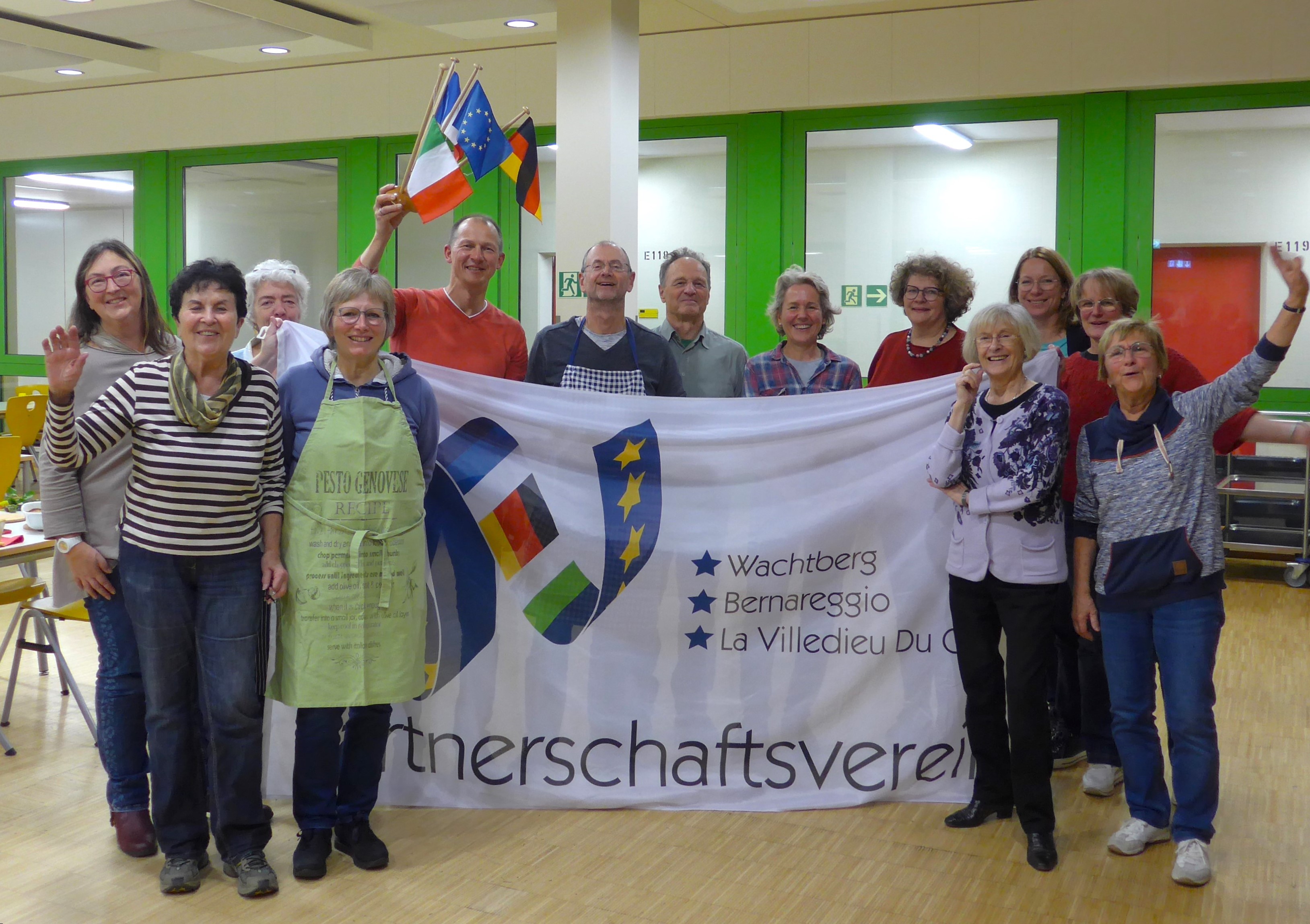 Teilnehmer des französischen Kochabends mit Parnerschaftsfahne