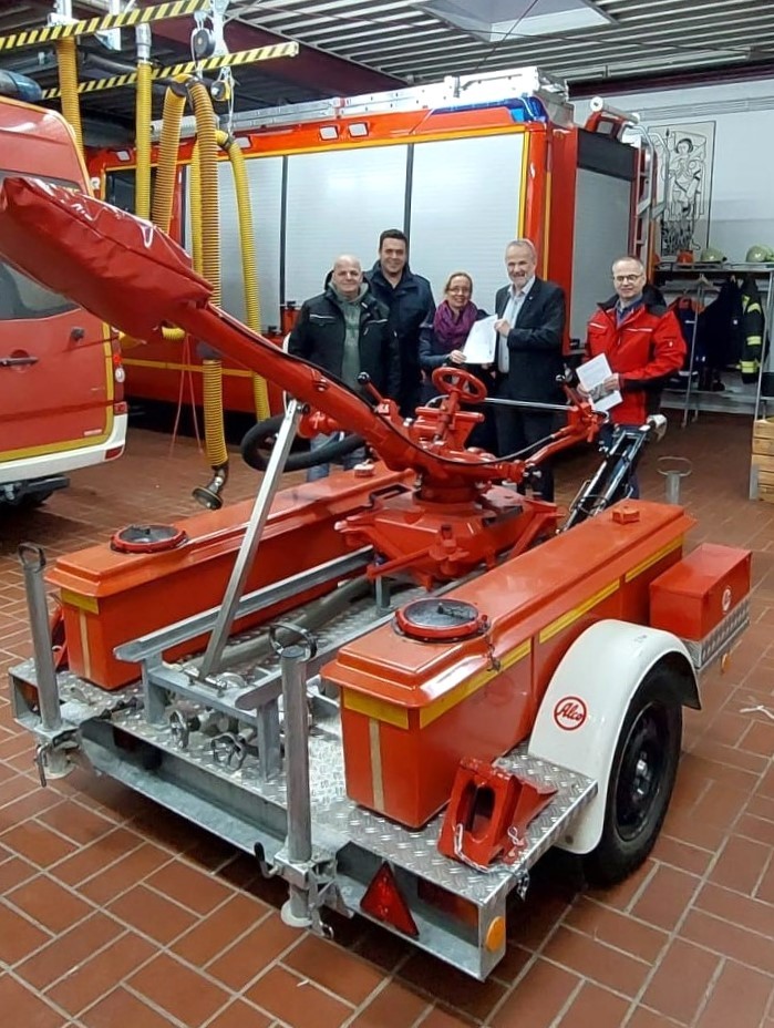 Bürgermeister Schmidt steht mit Vertretern der Feuerwehr und von Wachtberg4Help neben dem Schaumwasserwerfer.