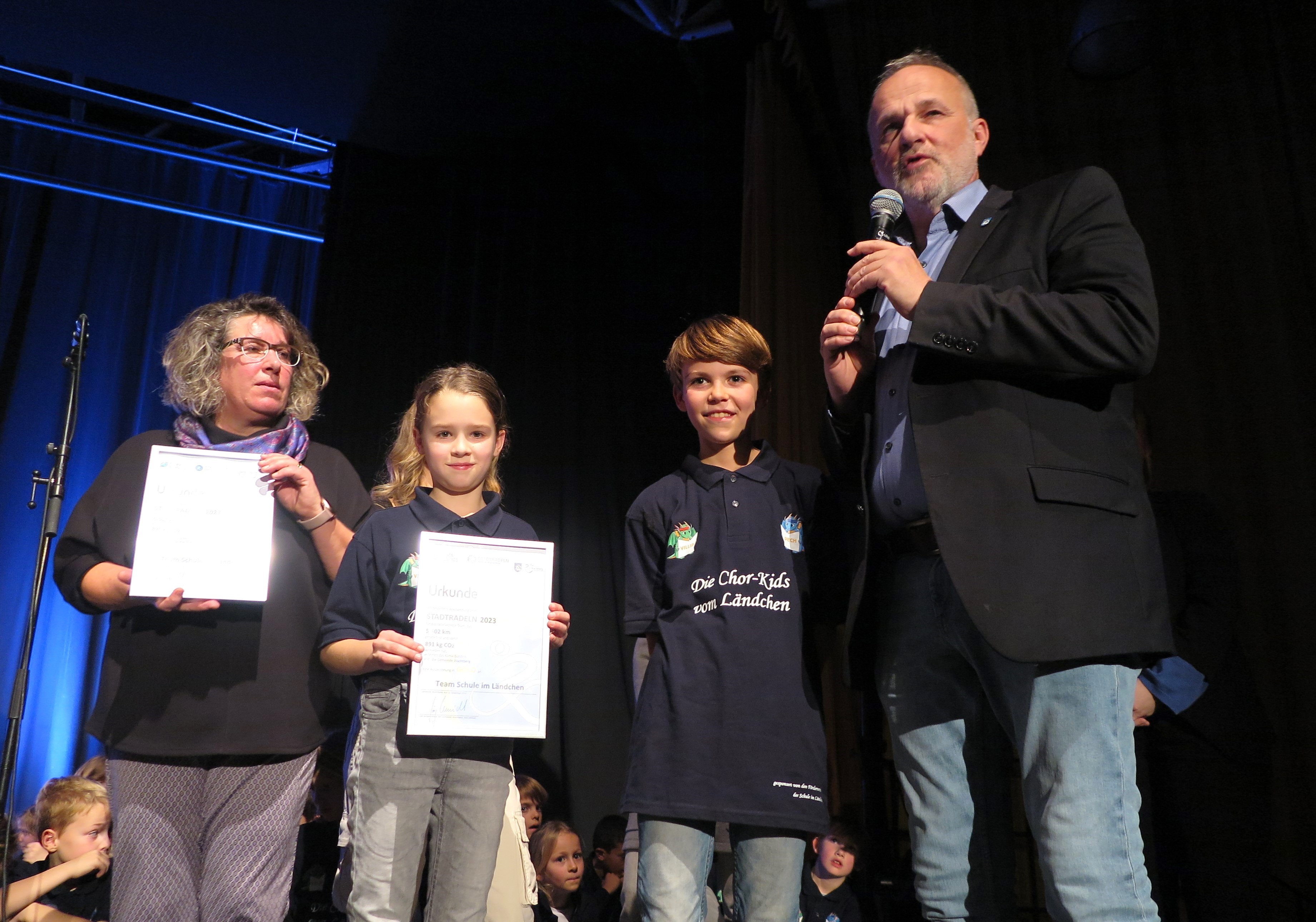 Bürgermeister Jörg Schmidt, Schulleiterin Elke Weyers mit zwei Kindern zeigen die Urkunden
